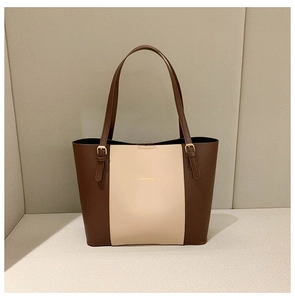 Detailed shot of two-tone tote bag featuring golden hardware and FASHION & BAG logo