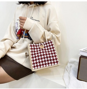 Detail of red houndstooth canvas tote with wooden button and rope handle texture