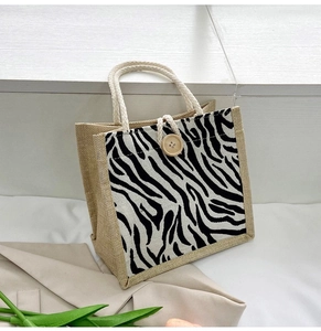 Detail of jute tote bag with zebra print panel and round wooden button closure