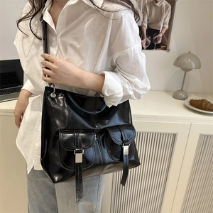 Large black glossy faux leather tote bag with double front pockets and metallic buckles
