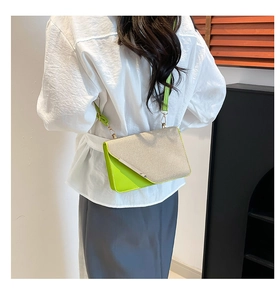 Détail des coutures contrastées et de la texture tissée d'un sac bandoulière vert
