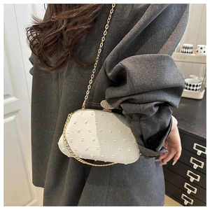Detailansicht der weißen Clutch mit Perlenstruktur, Strass-Kugelverschluss und Goldkette