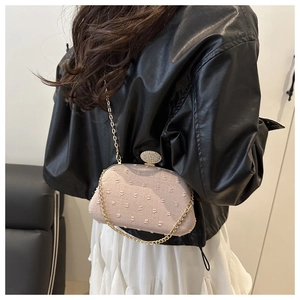 Close-up of pink tweed heart-patterned evening bag with shimmering diamond buckle detail