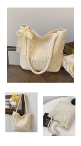 Detail of handwoven straw tote bag featuring thick cotton rope handles and lace bow accent