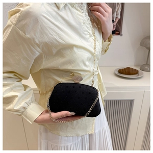 Chic black velvet evening bag with dotted texture and diamond lock on a crossbody chain