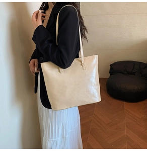 Minimalist cream tote bag with leather texture styled with a chic urban commuter outfit