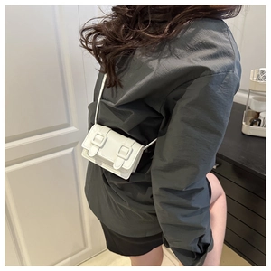 Detailed view of a white mini flap bag featuring stylish double square buckles on the strap