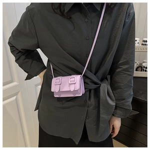 Detail of light purple mini crossbody bag with buckle decor and fine PU leather texture