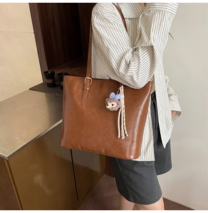Brown leather tote bag with hedgehog charm detail shown on model for daily commuting
