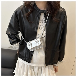 Detailed view of a mini silver square crossbody bag on a black leather jacket
