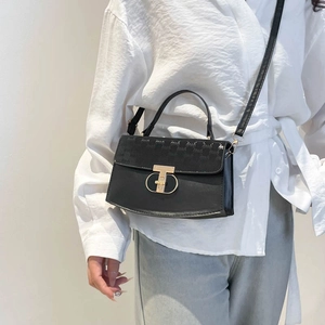 Elegant black top-handle handbag with gold T-lock and textured flap for stylish women