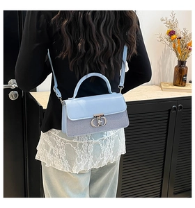 Rear view of model wearing light blue square bag with metal CD buckle and adjustable strap