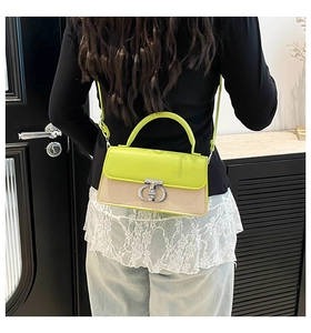 Detail of a contrast crossbody bag featuring neon green leather and woven straw texture