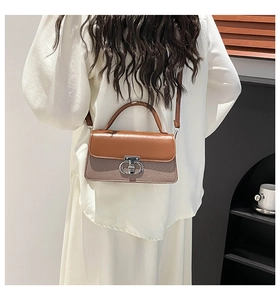 Detailed close-up of brown leather and fabric handbag with a silver twist-lock