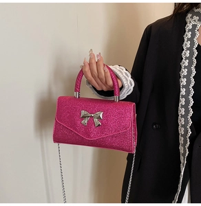 Détail du sac à main rose pailleté avec boucle nœud papillon argenté et bandoulière chaîne