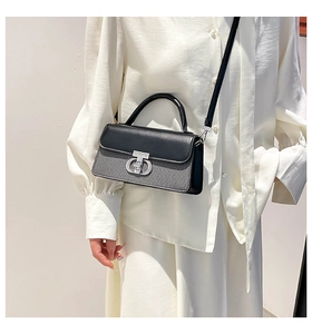 Detail of silver double-ring lock on black and grey textured crossbody handbag