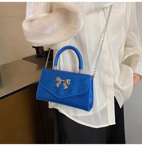 Détail du sac à paillettes bleues avec boucle papillon argentée et bandoulière