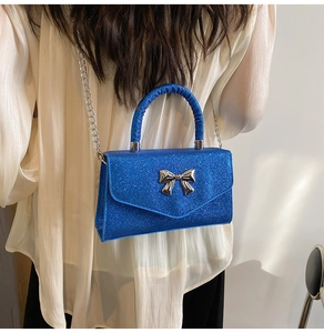Détail du sac à main à paillettes bleu vif avec fermoir papillon argenté et bandoulière