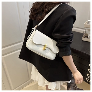 Detailed side view of white faux leather crossbody bag with elegant gold metal clasp
