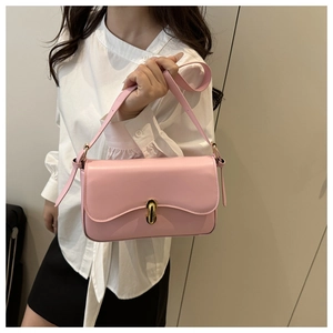 Detailed shot of a pale pink flap crossbody bag featuring a golden metallic buckle closure
