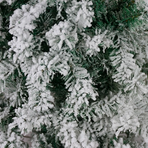 Close-up of artificial Christmas tree branches with realistic flocked white snow coating