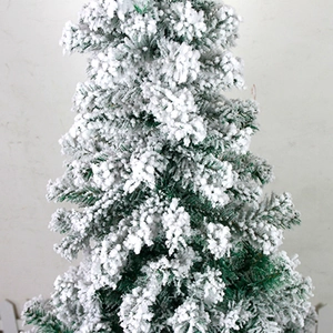 Close-up of artificial flocked Christmas tree needles with realistic white snow texture
