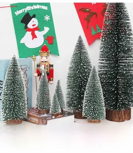 Miniature flocked Christmas cedar trees with wooden bases in festive holiday decor setting