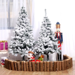 Frosted white Christmas tree with flocked snow and rustic wooden log picket fence set