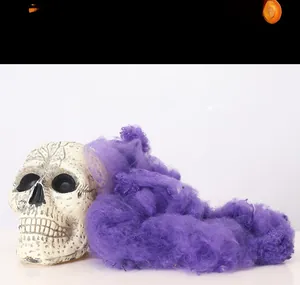 Close-up of purple stretchable spider web with realistic resin skull for Halloween decor