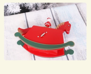 Close-up of wooden Christmas rocking horse music box with Santa Claus and metal clockwork