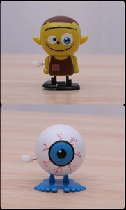 Detail of wind-up Halloween zombie and bloodshot eyeball toys on a wood surface