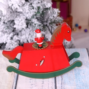 Red wooden Christmas rocking horse music box with Santa Claus on a green base