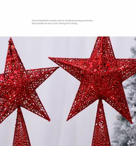Détail de la cime de sapin étoile rouge à paillettes avec motif en fer ajouré