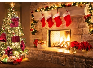 Close-up of red glossy Christmas tree ornaments including star and boot on a lighted tree