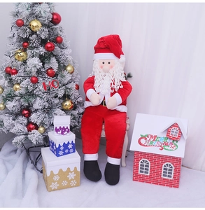 Detailed plush Santa Claus doll with red hat and white beard in festive indoor setting