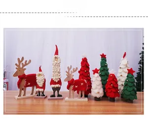 Detalle de árboles de Navidad de fieltro y adornos de mesa de renos de madera hechos a mano