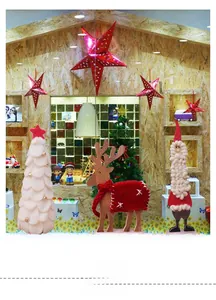 Detalle de set decorativo navideño con reno de madera, pino y figura de Papá Noel