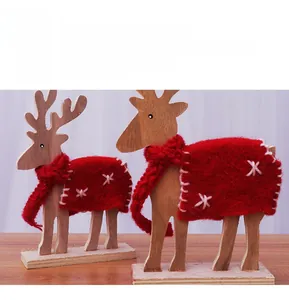 Detalle de dos figuras de renos de madera con bufandas de punto rojas de Navidad