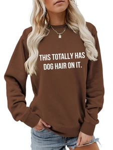 Close-up of the white 'THIS TOTALLY HAS DOG HAIR ON IT' lettering on a brown sweatshirt