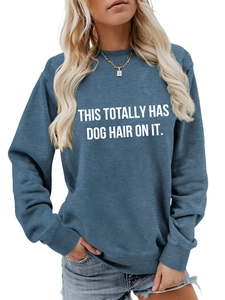Close-up of ribbed crew neck and white text print on blue long sleeve sweatshirt