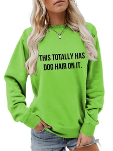 Detail of neon green crewneck sweatshirt featuring bold black printed dog lover slogan