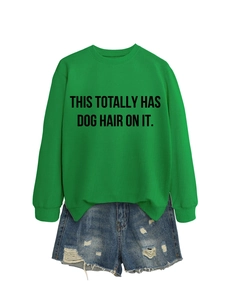 Flat lay of green round neck sweatshirt with humor text and ripped denim shorts