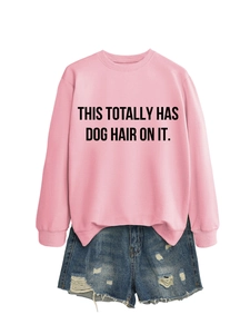 Flat lay of pink crewneck sweatshirt with text and distressed denim shorts on white background