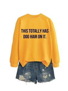 Flat lay of yellow sweatshirt with dog hair slogan and distressed denim shorts