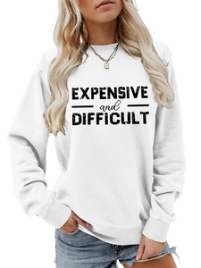 Close-up of black 'EXPENSIVE and DIFFICULT' lettering on white crewneck sweatshirt