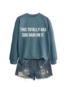 Close-up of grey-blue sweatshirt with white slogan and distressed denim shorts