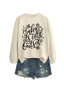 Detalle del estampado baby it's cold outside en sudadera blanca y shorts vaqueros