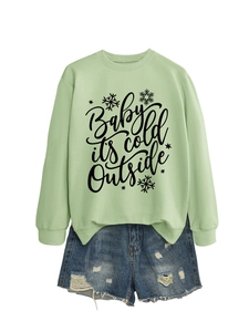 Detalle de sudadera verde menta con estampado y pantalones cortos de mezclilla azul