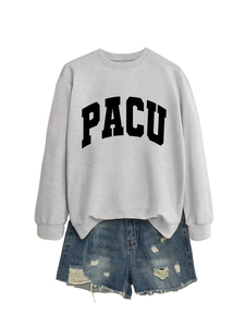 Detail view of light grey crewneck sweatshirt with PACU print and ripped denim shorts