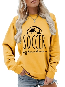 Detail of a yellow crewneck sweatshirt featuring a black Soccer Grandma print and soccer icon